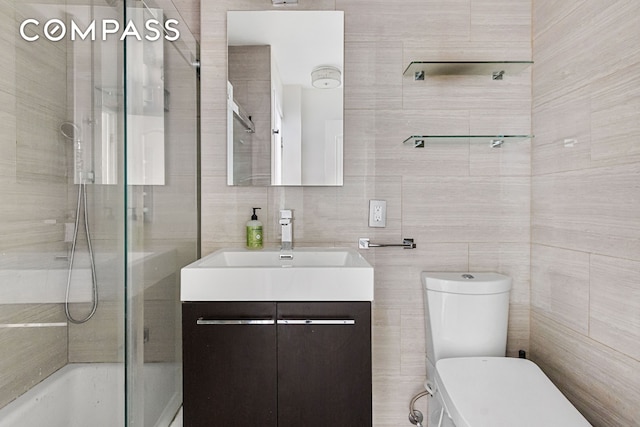 bathroom featuring toilet, tile walls, tub / shower combination, and vanity