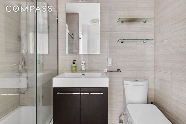 426 W 46th St Unit 1A, New York City, NY 10036 - full bath featuring tile walls, toilet, vanity, and tub / shower combination