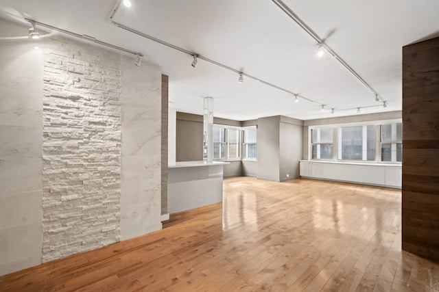 unfurnished living room with light hardwood / wood-style flooring and track lighting