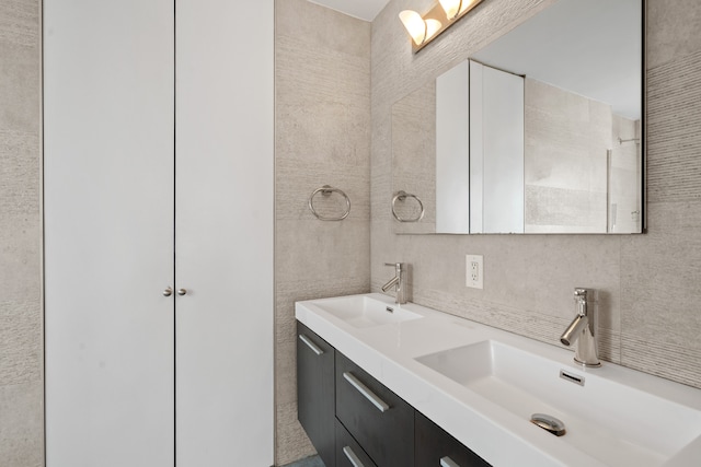 full bath with tile walls, backsplash, and double vanity