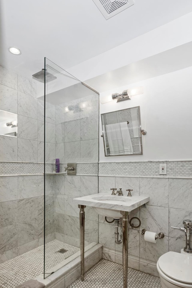 bathroom featuring toilet, walk in shower, and tile walls