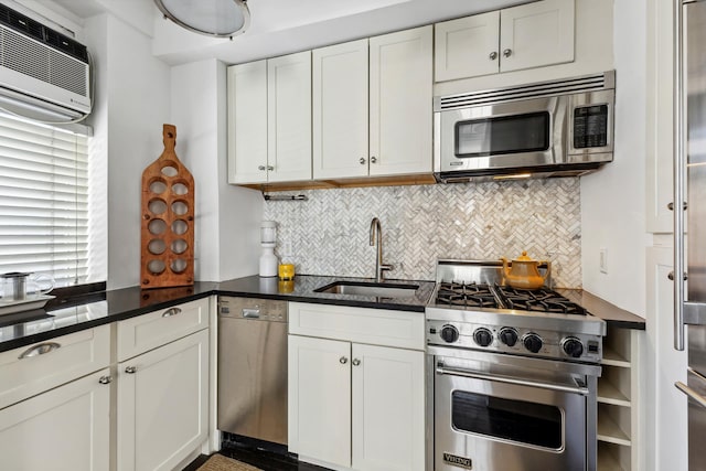 kitchen with a sink, decorative backsplash, an AC wall unit, stainless steel appliances, and white cabinetry