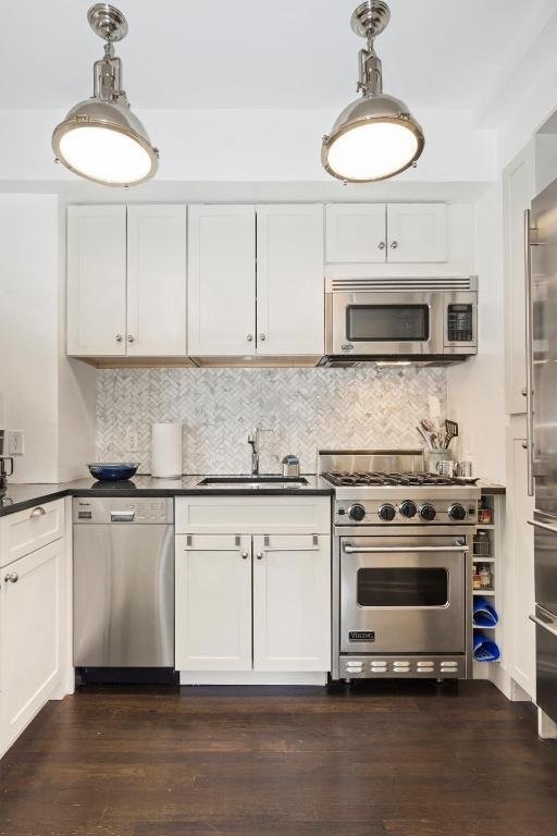 kitchen featuring white cabinets, dark hardwood / wood-style floors, sink, and high quality appliances