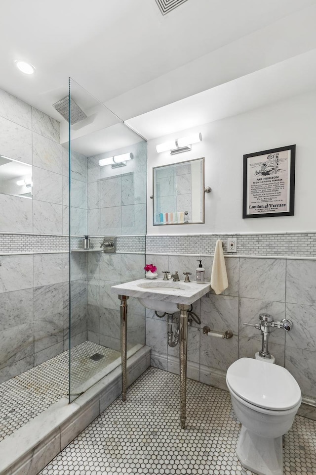 full bath with visible vents, walk in shower, toilet, tile patterned floors, and tile walls