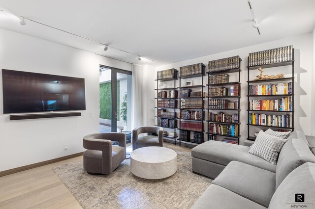 living area with track lighting and light hardwood / wood-style floors