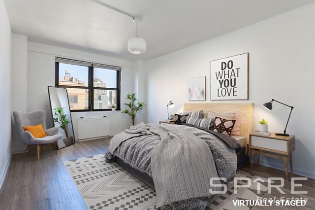 bedroom with baseboards and wood finished floors