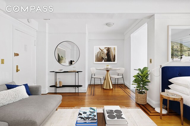 living room with a brick fireplace and light hardwood / wood-style flooring