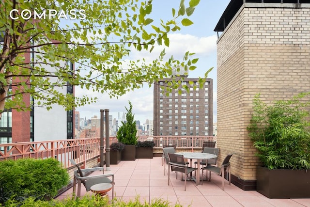 view of patio / terrace with a view of city and outdoor dining area