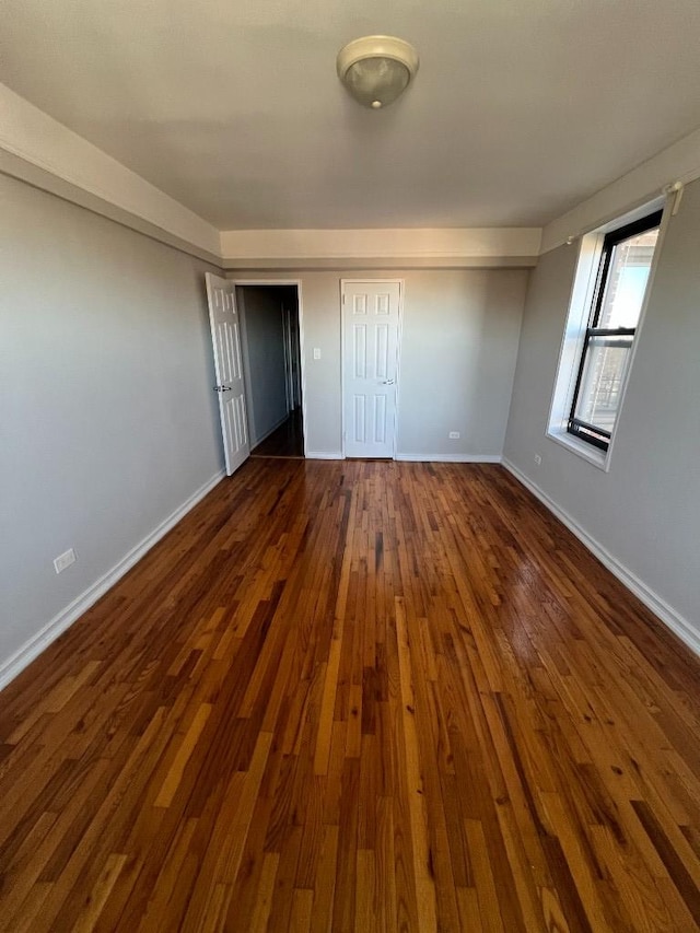 unfurnished bedroom featuring dark wood finished floors and baseboards