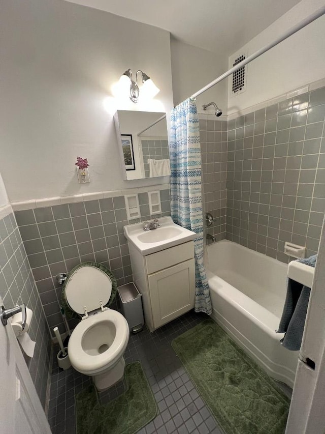 full bath featuring visible vents, toilet, shower / bath combo with shower curtain, tile patterned floors, and tile walls