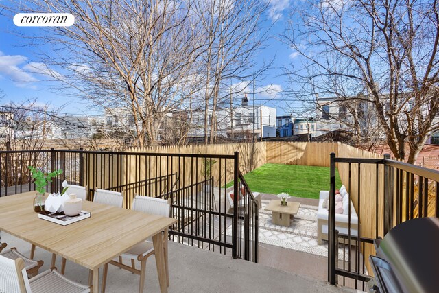 wooden deck with a yard, a patio, outdoor dining space, a grill, and a fenced backyard