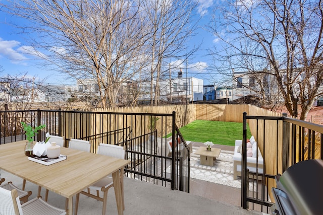 deck featuring a yard, outdoor dining space, a patio area, a grill, and a fenced backyard