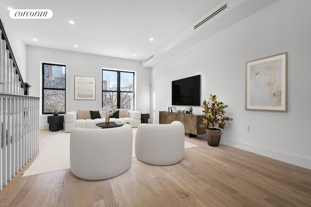 living area with wood finished floors, visible vents, recessed lighting, and baseboards