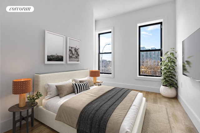 bedroom featuring wood finished floors, baseboards, and multiple windows