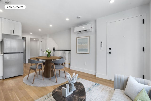 dining area featuring light wood-style flooring, recessed lighting, visible vents, baseboards, and a wall mounted air conditioner