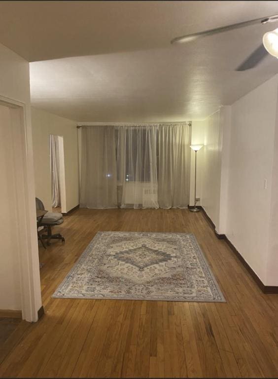 interior space with wood-type flooring and ceiling fan