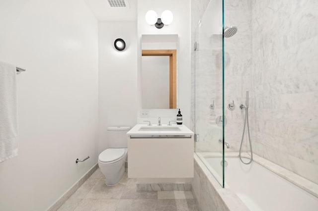 bathroom with toilet, vanity, tiled shower / bath, and tile patterned floors