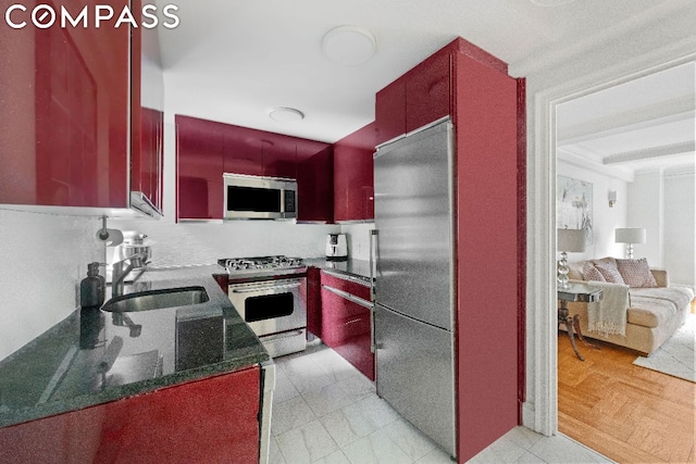 kitchen featuring dark stone countertops, sink, and stainless steel appliances