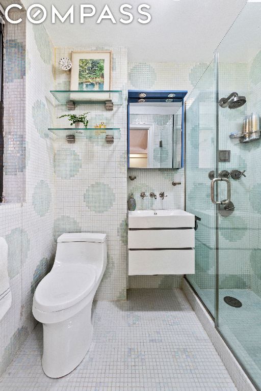 bathroom featuring vanity, toilet, an enclosed shower, and tile patterned flooring