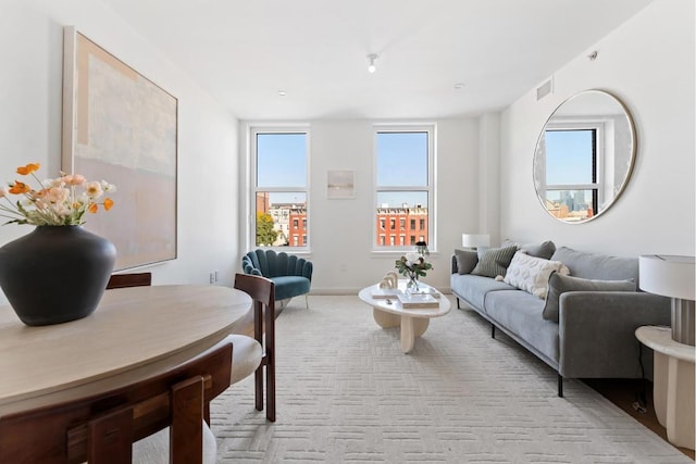 living room with light carpet, visible vents, and baseboards