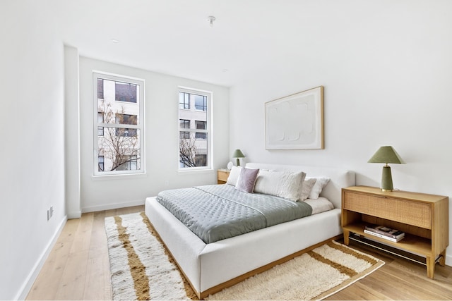 bedroom with light wood-type flooring and baseboards