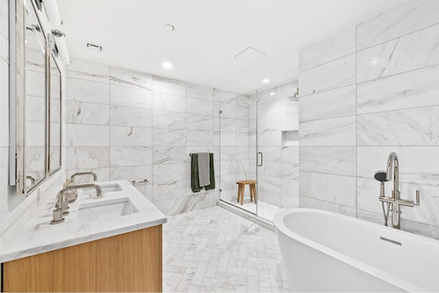 bathroom with a stall shower, a freestanding bath, tile walls, and double vanity