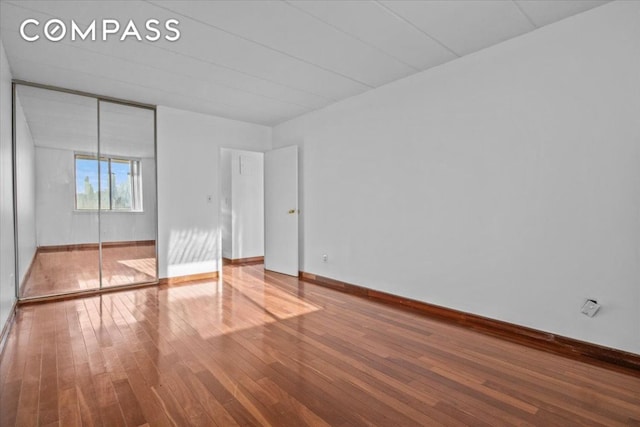 unfurnished bedroom featuring hardwood / wood-style floors and a closet