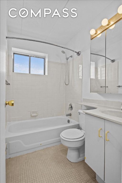 full bathroom featuring vanity, tile patterned floors, toilet, and tiled shower / bath