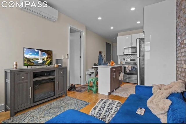 living room with a wall unit AC and light hardwood / wood-style flooring