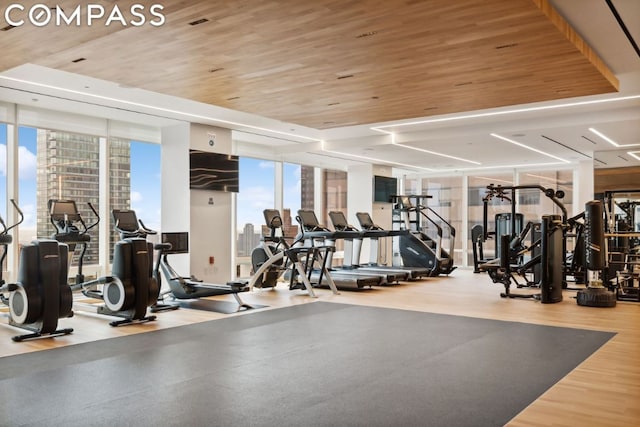 gym with expansive windows, wood-type flooring, and wooden ceiling