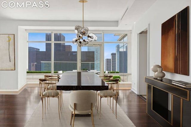 dining room with an inviting chandelier, dark hardwood / wood-style flooring, a healthy amount of sunlight, and a wall of windows