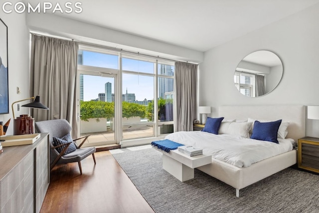 bedroom featuring multiple windows, access to exterior, and dark hardwood / wood-style flooring