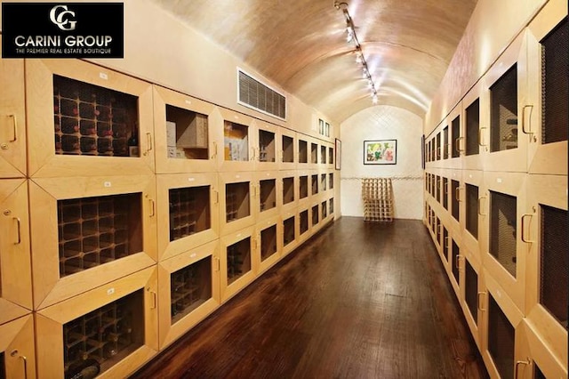 wine room featuring visible vents, track lighting, lofted ceiling, and hardwood / wood-style floors