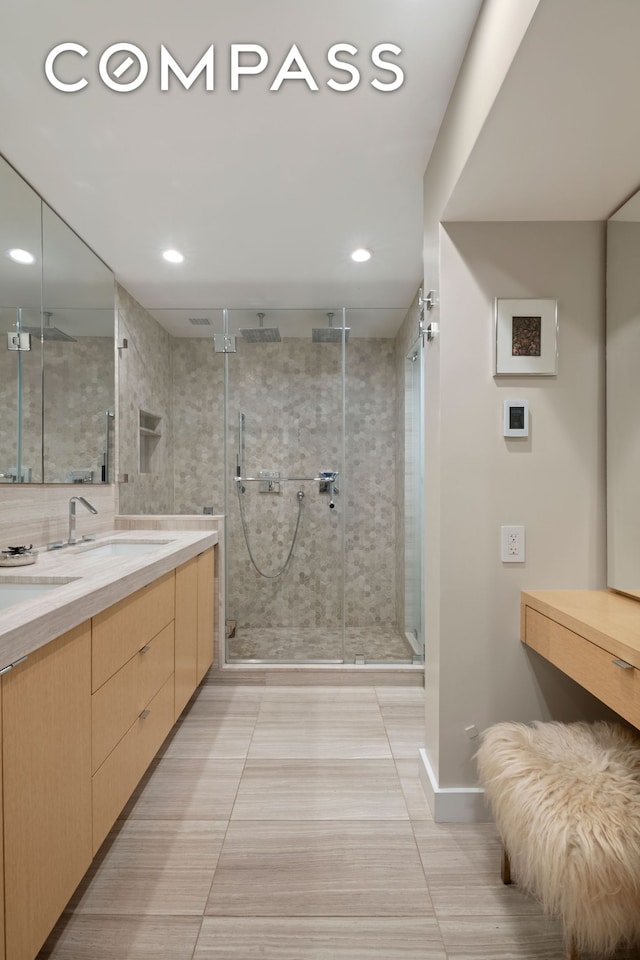 bathroom with a shower stall, double vanity, recessed lighting, and tile patterned floors