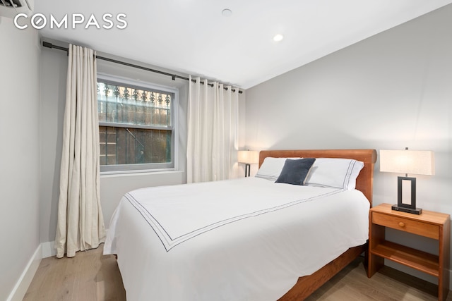 bedroom with wood finished floors, baseboards, and recessed lighting