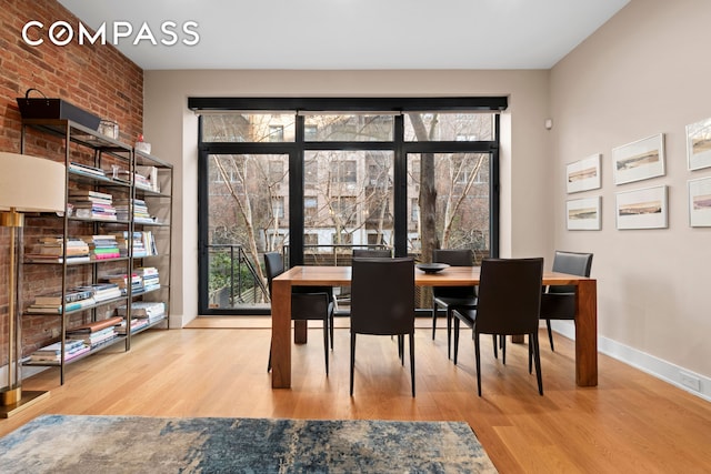 dining space with wood finished floors, plenty of natural light, and baseboards