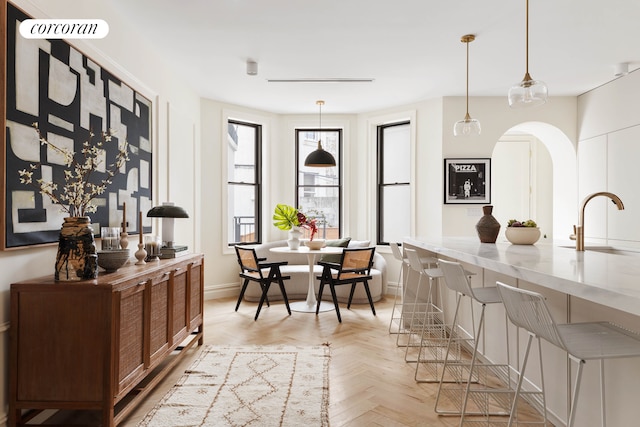 dining space featuring arched walkways and baseboards