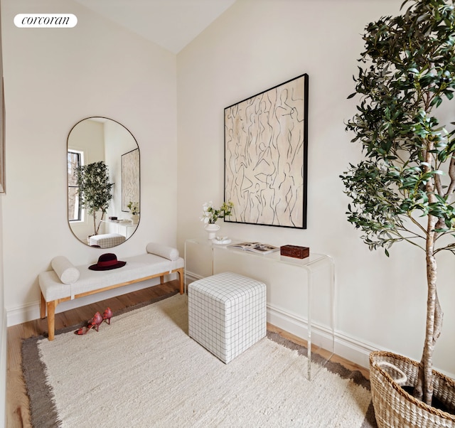 living area featuring baseboards, visible vents, and wood finished floors