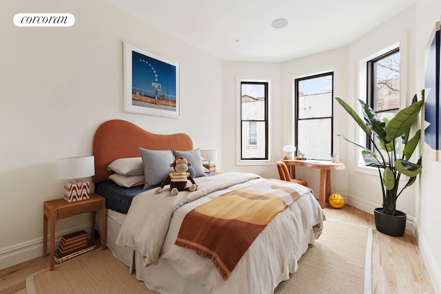 bedroom with visible vents, light wood-style flooring, and baseboards