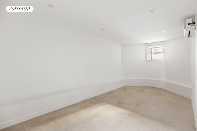 spare room with light tile patterned floors, recessed lighting, visible vents, baseboards, and an AC wall unit