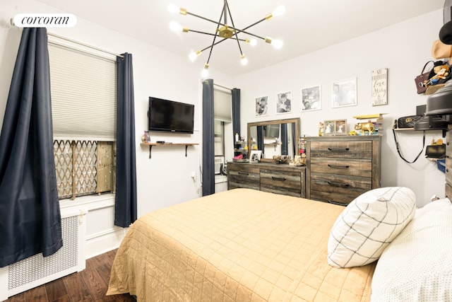 bedroom with dark wood-type flooring and a notable chandelier