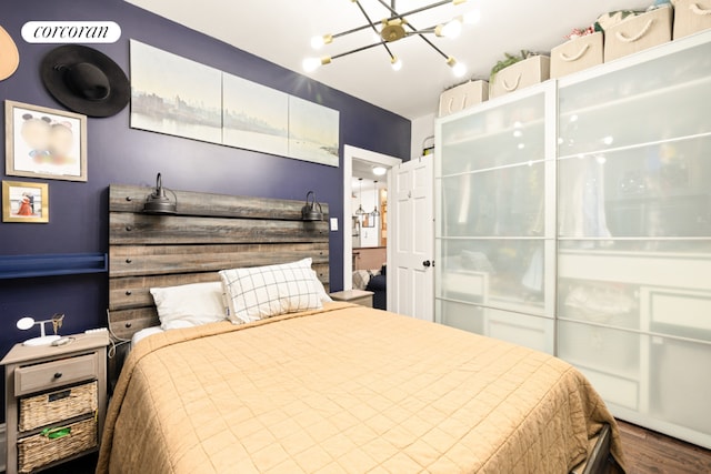 bedroom with hardwood / wood-style floors and a notable chandelier