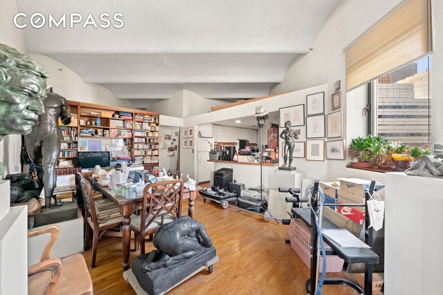 unfurnished living room with light hardwood / wood-style floors and vaulted ceiling with beams