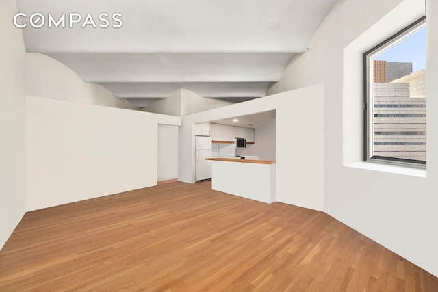 57 Warren St Unit 7, New York City, NY 10007 - unfurnished living room featuring light wood-type flooring and vaulted ceiling