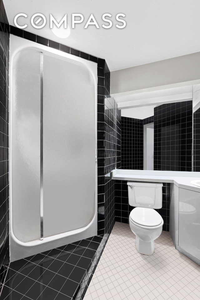 57 Warren St Unit 7, New York City, NY 10007 - bathroom featuring toilet, tile walls, tile patterned floors, and a shower