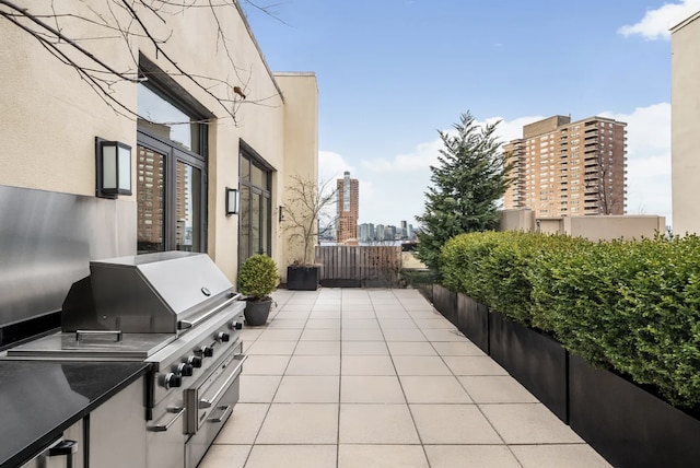 view of patio with a view of city, area for grilling, and a grill