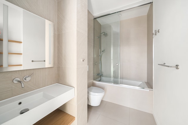 full bath with vanity, enclosed tub / shower combo, tile patterned flooring, tile walls, and toilet