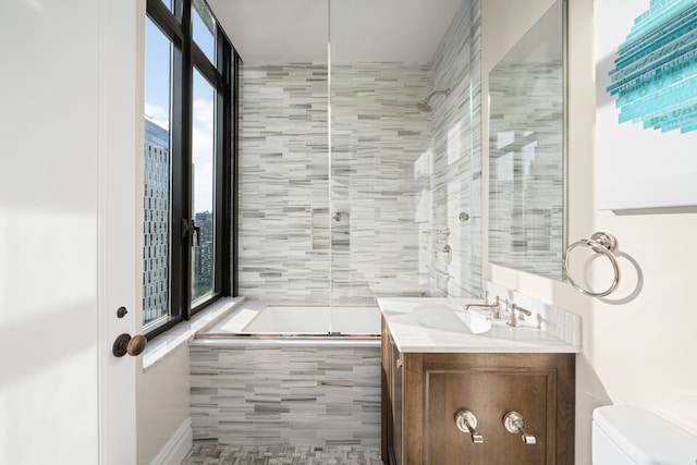 full bathroom with vanity, toilet, tiled tub, and tiled shower