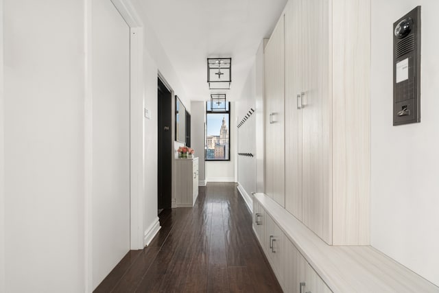 corridor with dark wood-type flooring and baseboards