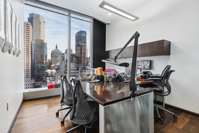 50 W 47th St Unit 1808, New York City, NY 10036 - home office featuring expansive windows, wood finished floors, a skyline view, and baseboards